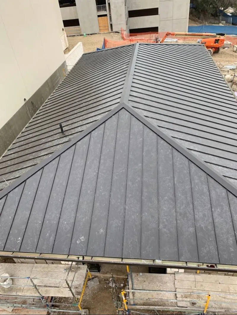 Commercial metal roof construction with crane equipment in Palm Springs